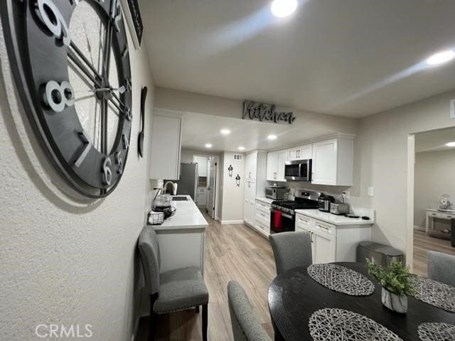 9827 Estacia Ct, Rancho Cucamonga, CA 91730 - kitchen featuring stainless steel appliances, light wood-style flooring, white cabinets, recessed lighting, and light countertops