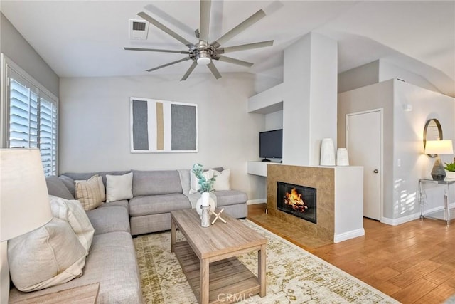 591 Shadow Tree Dr, Oceanside, CA 92058 - living area featuring wood finished floors, ceiling fan, vaulted ceiling, and a fireplace