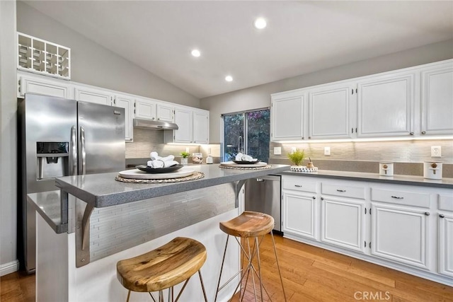 591 Shadow Tree Dr, Oceanside, CA 92058 - kitchen with appliances with stainless steel finishes, backsplash, white cabinets, light wood-style floors, and lofted ceiling