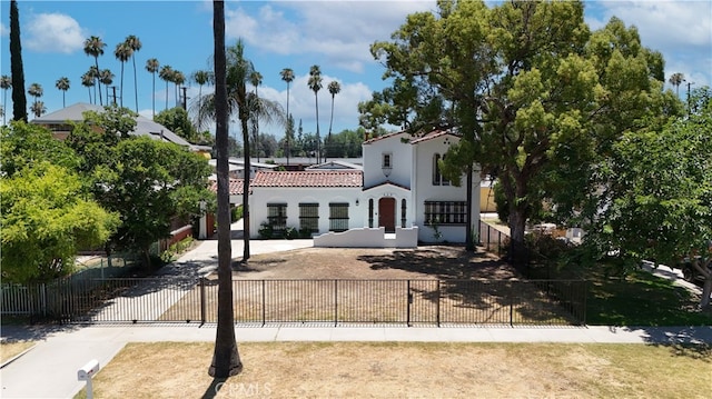 425 W 17th St, San Bernardino, CA 92405 - mediterranean / spanish house featuring a fenced front yard, a tile roof, and stucco siding