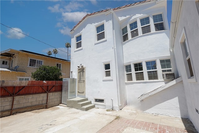 425 W 17th St, San Bernardino, CA 92405 - back of property featuring stucco siding, cooling unit, and a patio
