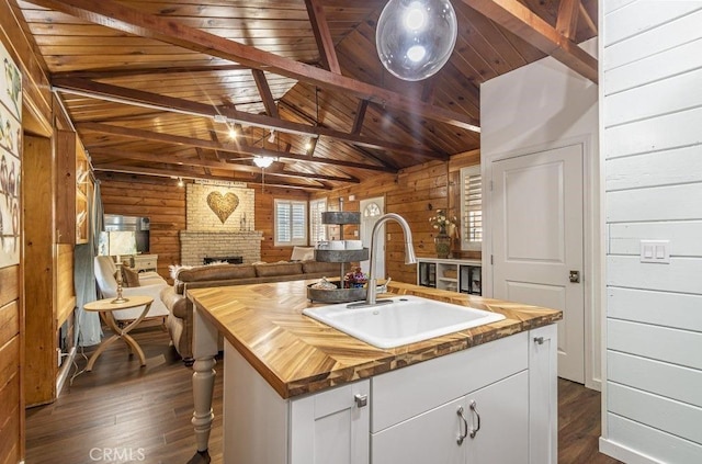 35853 Sierra Linda Dr, Wishon, CA 93669 - kitchen with wood counters, wood walls, dark wood-style flooring, a fireplace, and white cabinetry