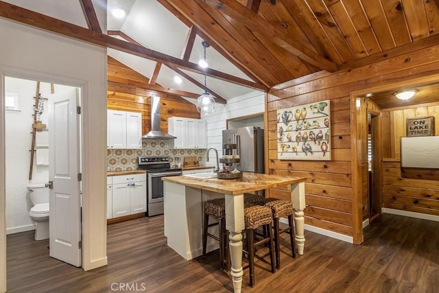 35853 Sierra Linda Dr, Wishon, CA 93669 - kitchen featuring stainless steel appliances, wall chimney exhaust hood, butcher block counters, wood walls, and white cabinets