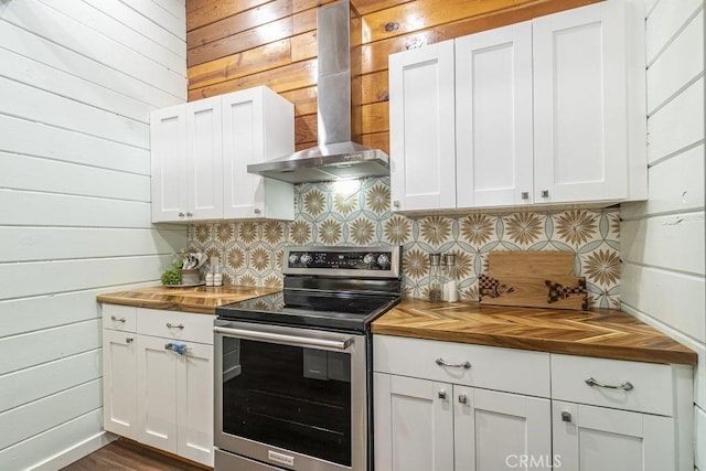 35853 Sierra Linda Dr, Wishon, CA 93669 - kitchen with stainless steel electric stove, wall chimney range hood, butcher block counters, tasteful backsplash, and wood walls