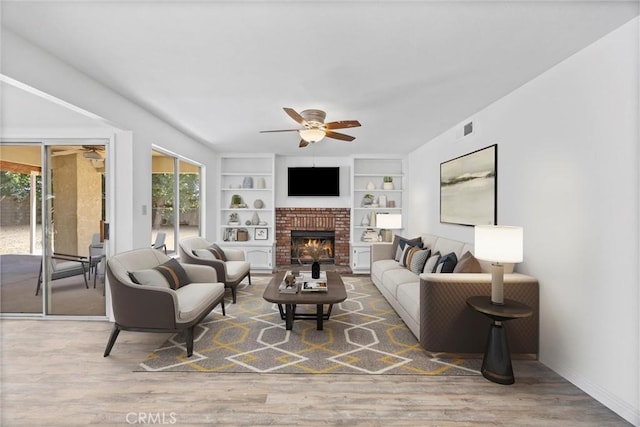 601 Las Arenas Ct, Bakersfield, CA 93314 - living area with ceiling fan, wood finished floors, a brick fireplace, and built in shelves