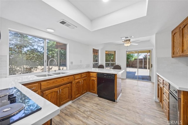 601 Las Arenas Ct, Bakersfield, CA 93314 - kitchen featuring black dishwasher, light countertops, a peninsula, backsplash, and light wood-type flooring
