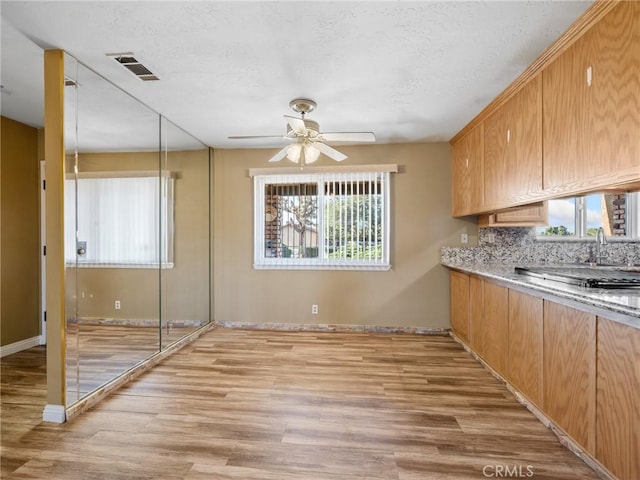 17911 Juniper St, Hesperia, CA 92345 - kitchen with plenty of natural light, light wood-type flooring, ceiling fan, light countertops, and a textured ceiling