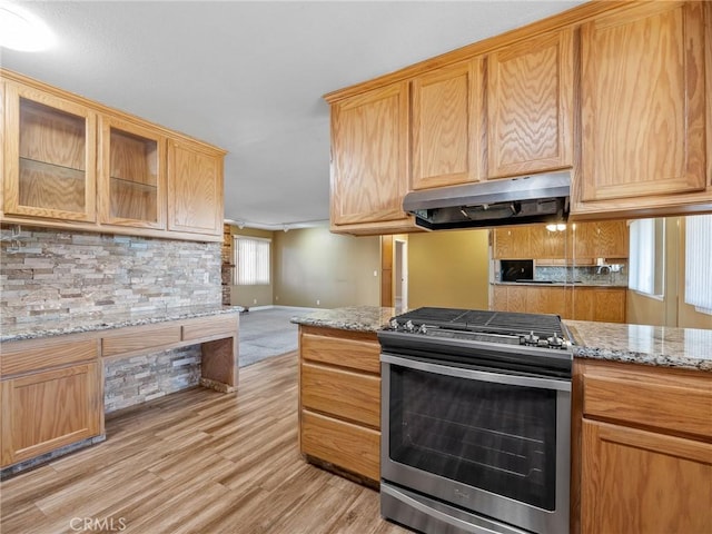 17911 Juniper St, Hesperia, CA 92345 - kitchen with gas stove, under cabinet range hood, light wood-type flooring, decorative backsplash, and light stone counters