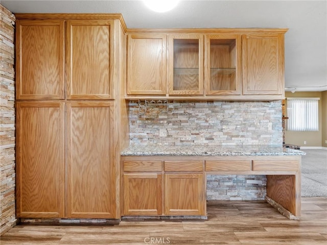 17911 Juniper St, Hesperia, CA 92345 - kitchen with backsplash, light stone countertops, glass insert cabinets, and light wood finished floors