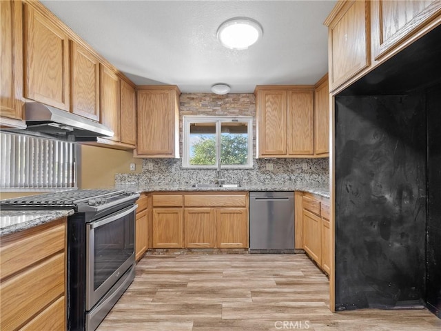 17911 Juniper St, Hesperia, CA 92345 - kitchen featuring stainless steel appliances, under cabinet range hood, light wood-type flooring, backsplash, and light stone countertops