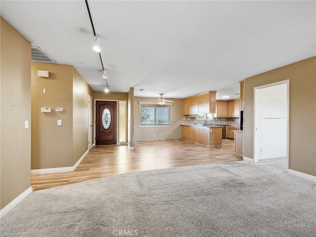 17911 Juniper St, Hesperia, CA 92345 - unfurnished living room with light colored carpet, track lighting, a ceiling fan, and light wood-style floors