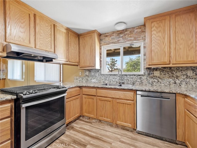 17911 Juniper St, Hesperia, CA 92345 - kitchen featuring appliances with stainless steel finishes, under cabinet range hood, decorative backsplash, light wood-style floors, and light stone countertops