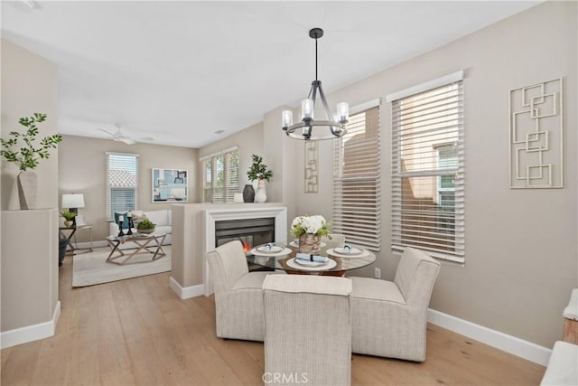 14 Tall Oak, Irvine, CA 92603 - dining area with light wood-style floors, a chandelier, a glass covered fireplace, and ceiling fan