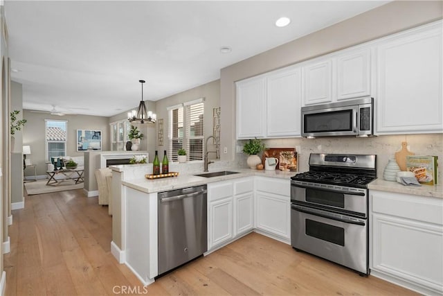 14 Tall Oak, Irvine, CA 92603 - kitchen featuring appliances with stainless steel finishes, white cabinets, a peninsula, and recessed lighting