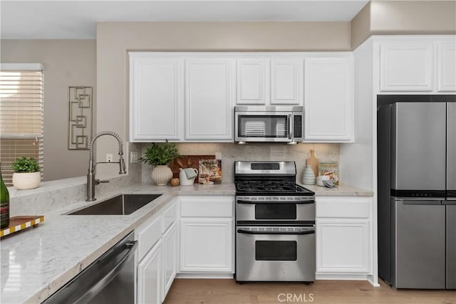 14 Tall Oak, Irvine, CA 92603 - kitchen with stainless steel appliances, light stone counters, white cabinets, and decorative backsplash