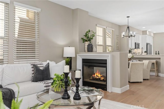 14 Tall Oak, Irvine, CA 92603 - living room featuring light wood-style floors, a glass covered fireplace, a chandelier, and recessed lighting