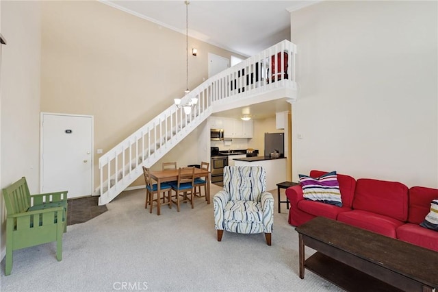 603 S Prospect Ave Unit 305, Redondo Beach, CA 90277 - living area featuring light colored carpet, stairway, a towering ceiling, and crown molding
