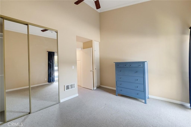 603 S Prospect Ave Unit 305, Redondo Beach, CA 90277 - unfurnished bedroom with carpet flooring, ornamental molding, a closet, a towering ceiling, and a ceiling fan