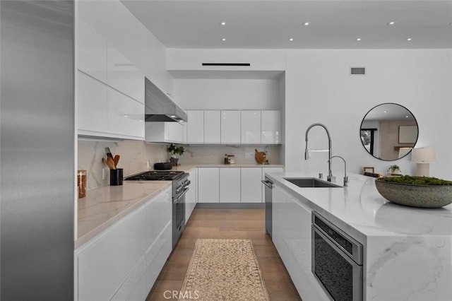 4764 Browndeer Ln, Rancho Palos Verdes, CA 90275 - kitchen with modern cabinets, appliances with stainless steel finishes, extractor fan, white cabinetry, and light stone countertops
