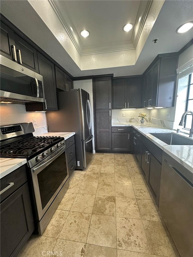2567 Plaza Del Amo Unit 205, Torrance, CA 90503 - kitchen featuring appliances with stainless steel finishes, a raised ceiling, crown molding, and light stone counters