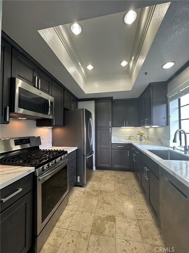 2567 Plaza Del Amo Unit 205, Torrance, CA 90503 - kitchen with appliances with stainless steel finishes, a raised ceiling, crown molding, recessed lighting, and dark cabinetry