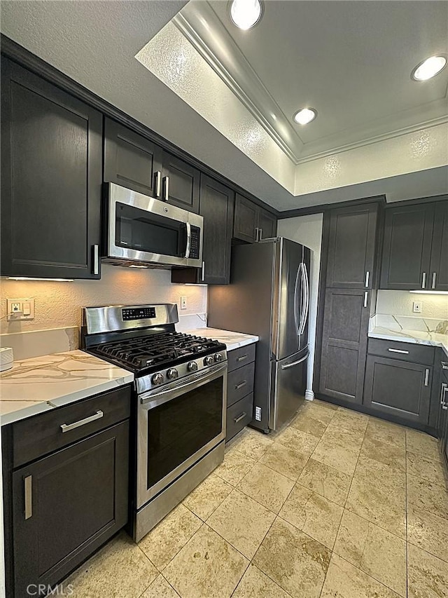 2567 Plaza Del Amo Unit 205, Torrance, CA 90503 - kitchen with appliances with stainless steel finishes, ornamental molding, a tray ceiling, dark cabinets, and tasteful backsplash
