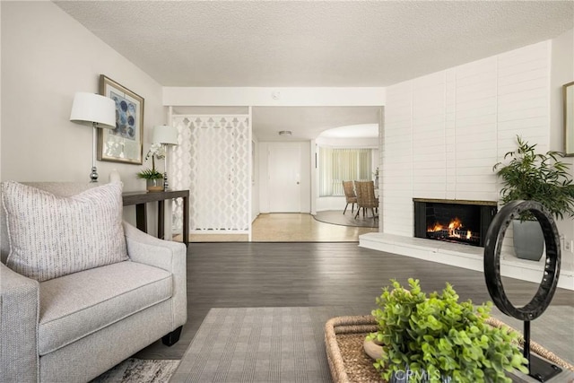 557 S Gardner Dr, Orange, CA 92866 - living area with wood finished floors, a large fireplace, and a textured ceiling