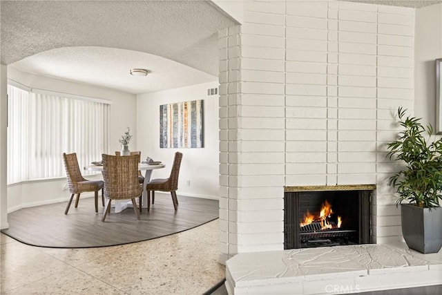 557 S Gardner Dr, Orange, CA 92866 - dining room featuring a textured ceiling and a fireplace