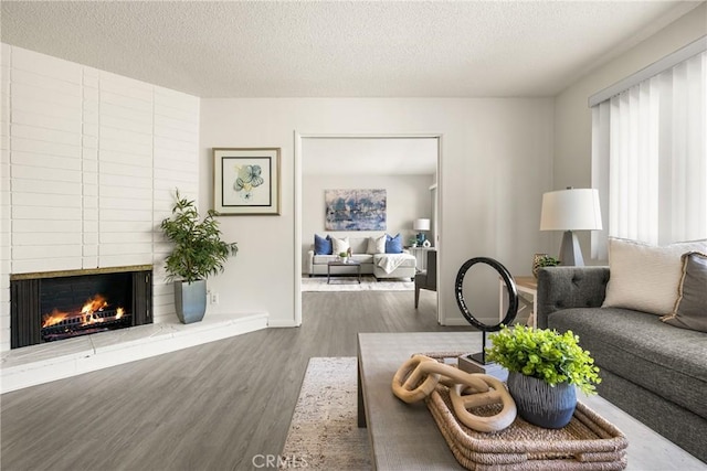 557 S Gardner Dr, Orange, CA 92866 - living area with wood finished floors, a large fireplace, and a textured ceiling