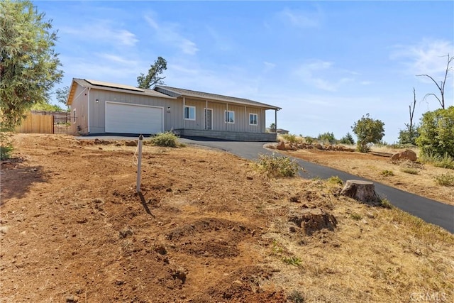 5616 Glen Way, Paradise, CA 95969 - ranch-style home with board and batten siding, a garage, solar panels, and driveway