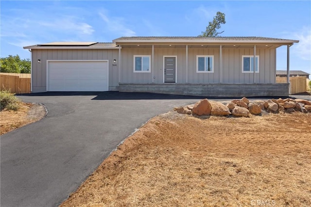 5616 Glen Way, Paradise, CA 95969 - ranch-style house featuring solar panels, a garage, asphalt driveway, and board and batten siding