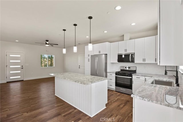 5616 Glen Way, Paradise, CA 95969 - kitchen with appliances with stainless steel finishes, ceiling fan, a center island, backsplash, and white cabinetry