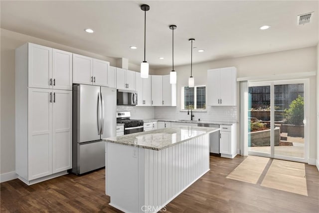 5616 Glen Way, Paradise, CA 95969 - kitchen with appliances with stainless steel finishes, white cabinets, a center island, backsplash, and dark wood-style flooring