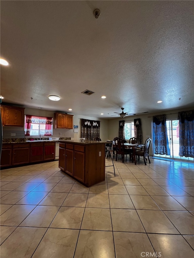 2932 Prospect Ave, Riverside, CA 92507 - kitchen with a kitchen island, recessed lighting, a textured ceiling, light tile patterned floors, and a ceiling fan