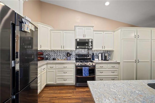 3310 Purple Sage Ln, Palmdale, CA 93550 - kitchen featuring appliances with stainless steel finishes, lofted ceiling, white cabinets, dark wood-style floors, and backsplash