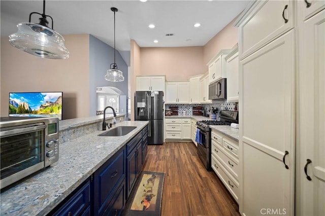 3310 Purple Sage Ln, Palmdale, CA 93550 - kitchen featuring stainless steel appliances, white cabinetry, light stone countertops, tasteful backsplash, and dark wood-style floors