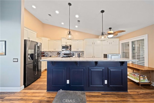 3310 Purple Sage Ln, Palmdale, CA 93550 - kitchen featuring stainless steel microwave, fridge with ice dispenser, range, tasteful backsplash, and wood finished floors