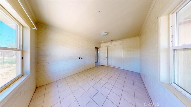 21845 Fox Ave, Apple Valley, CA 92307 - empty room with brick wall and light tile patterned flooring