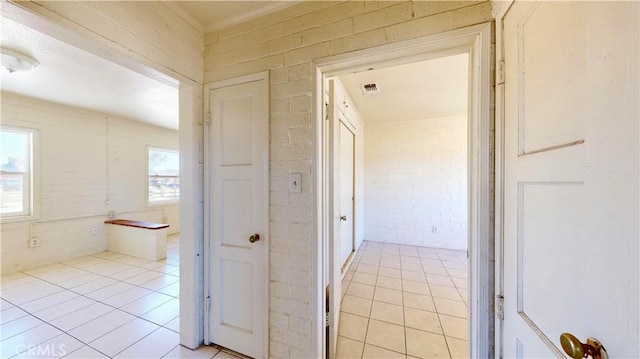 21845 Fox Ave, Apple Valley, CA 92307 - corridor featuring light tile patterned floors and brick wall