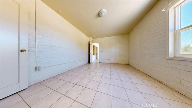 21845 Fox Ave, Apple Valley, CA 92307 - empty room with light tile patterned floors and brick wall