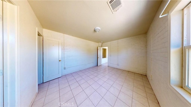 21845 Fox Ave, Apple Valley, CA 92307 - unfurnished room featuring brick wall and light tile patterned flooring