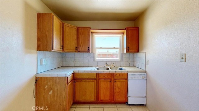 21845 Fox Ave, Apple Valley, CA 92307 - kitchen with dishwasher, backsplash, brown cabinetry, and light tile patterned floors