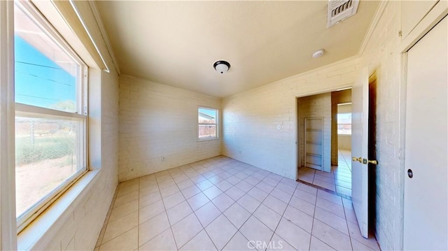 21845 Fox Ave, Apple Valley, CA 92307 - empty room with light tile patterned flooring and brick wall