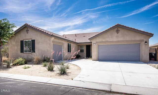 84319 Cigno Ct, Indio, CA 92203 - view of front of home with stucco siding, a garage, driveway, and a tile roof