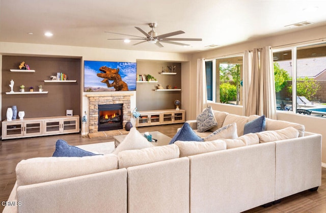 84319 Cigno Ct, Indio, CA 92203 - living room featuring ceiling fan, wood finished floors, a stone fireplace, recessed lighting, and built in features
