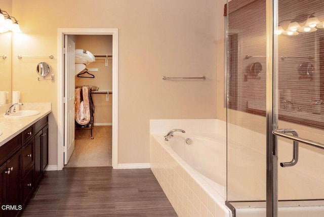 84319 Cigno Ct, Indio, CA 92203 - full bathroom with double vanity, a garden tub, a spacious closet, a stall shower, and wood finished floors