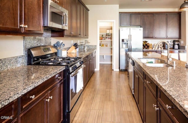 84319 Cigno Ct, Indio, CA 92203 - kitchen with stainless steel appliances, light stone countertops, dark brown cabinets, and backsplash