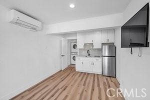25152 Mammoth Cir, Lake Forest, CA 92630 - kitchen with freestanding refrigerator, stacked washer / dryer, a wall mounted air conditioner, light countertops, and light wood finished floors