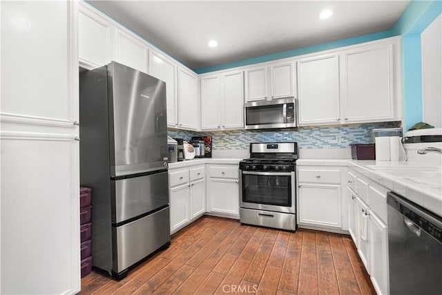 1335 Mc Fadden Dr, Fullerton, CA 92833 - kitchen with appliances with stainless steel finishes, dark wood-type flooring, white cabinets, tile counters, and recessed lighting