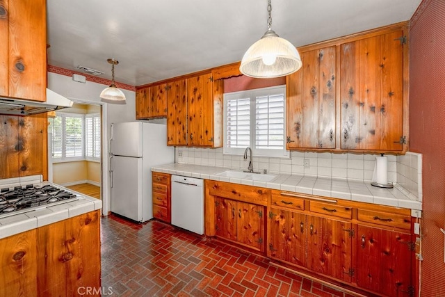 11009 Quill Ave, Sunland, CA 91040 - kitchen with white appliances, decorative backsplash, brick patterned flooring, and brown cabinets